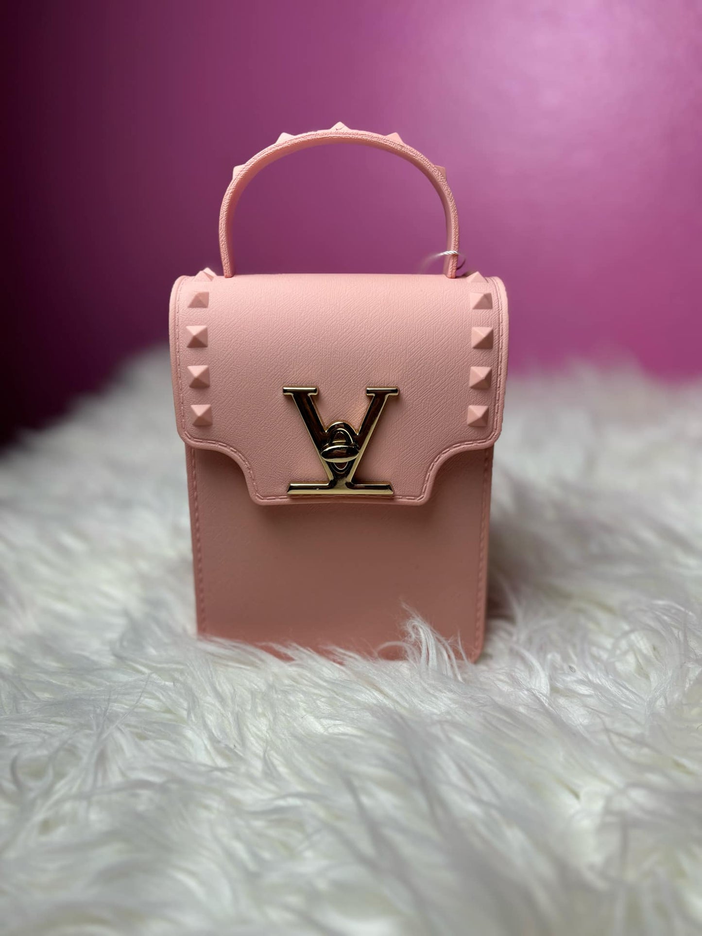 Pink handbag with a brand logo on a white and purple gradient background